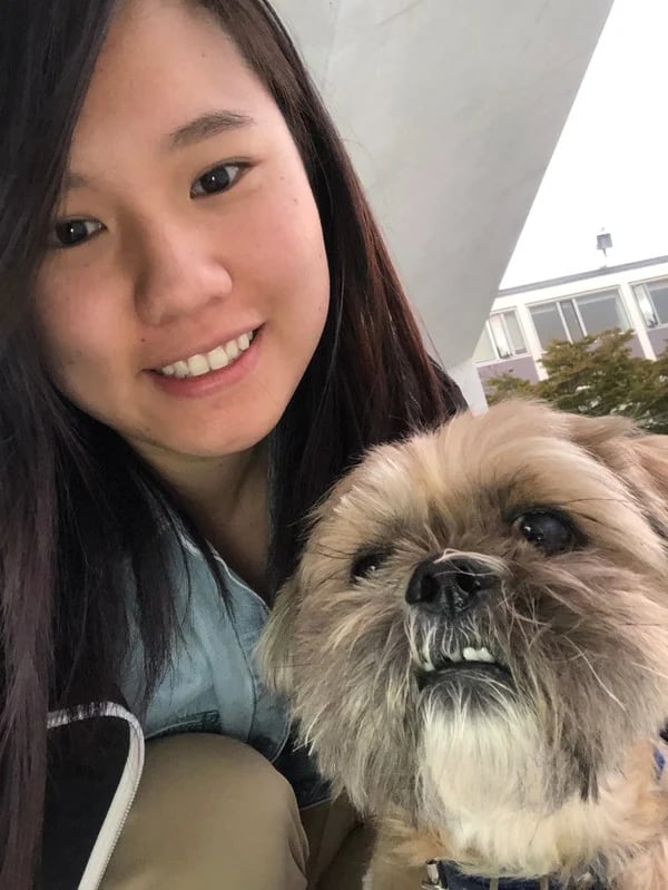 A picture of Jessamyn smiling while holding their dog, Mocha